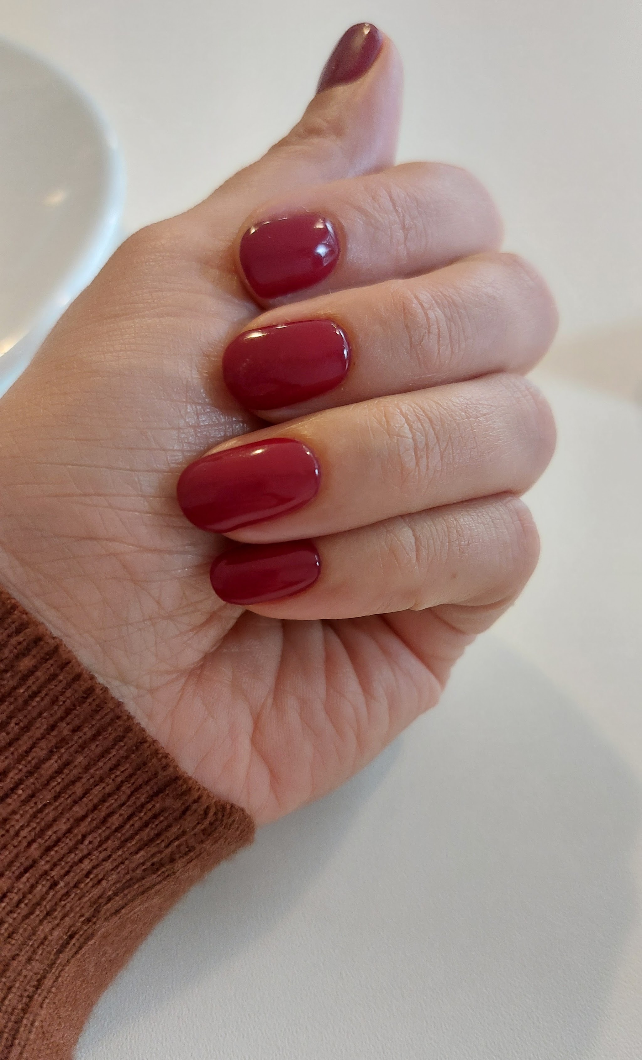 Donkerrode nagels naast een nagellamp